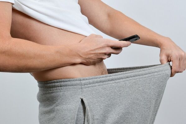 一个男人透过裤子看到增大的阴茎